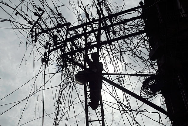 Groviglio elettrico - Un operaio alle prese con una matassa di cavi su una linea elettrica nella città indiana di Allahabad (Rajesh Kumar Singh/Ap)